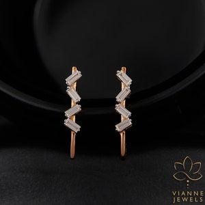 May include: A pair of rose gold earrings with a zig-zag design featuring five baguette-shaped diamonds.