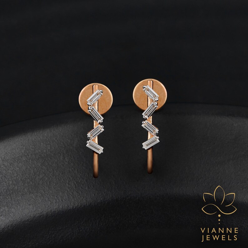 May include: A pair of rose gold earrings with a row of five baguette-shaped diamonds set in a zig-zag pattern.