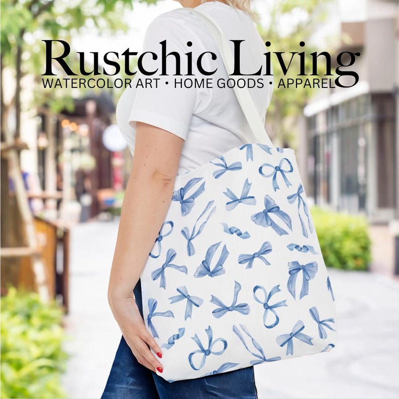 May include: A white tote bag with a blue watercolor bow pattern. The bag has the text "Rustchic Living" and "WATERCOLOR ART - HOME GOODS - APPAREL" printed on it.