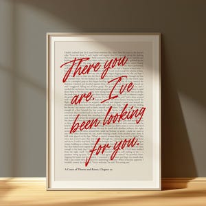 Peut inclure: Impression d'art encadrée avec du texte de "A Court of Thorns and Roses, Chapitre 20". Les mots "There you are. I've been looking for you" sont en rouge sur une page de livre vintage. L'impression est dans un cadre blanc.