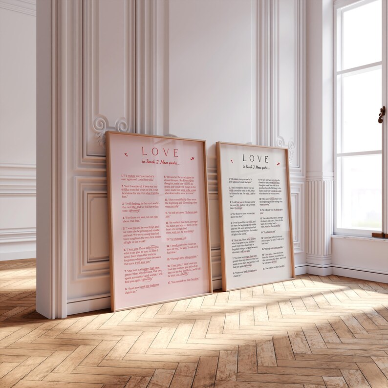 May include: Two framed prints with the word "LOVE" and text from Sarah J. Maas quotes. One print has a pink background, the other is off-white. Both are in light brown frames and lean against a white wall and a window.