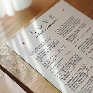 May include: A printed page with the word "LOVE" in large letters, followed by "in Sarah J. Maas quotes." The page features quotes about love, with some words highlighted in red. The paper is on a wooden surface.