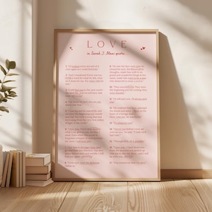May include: A framed print with a pink background features quotes from Sarah J. Maas's books in red text. The word "LOVE" is at the top, with small heart accents. The quotes are numbered and arranged in a vertical format.