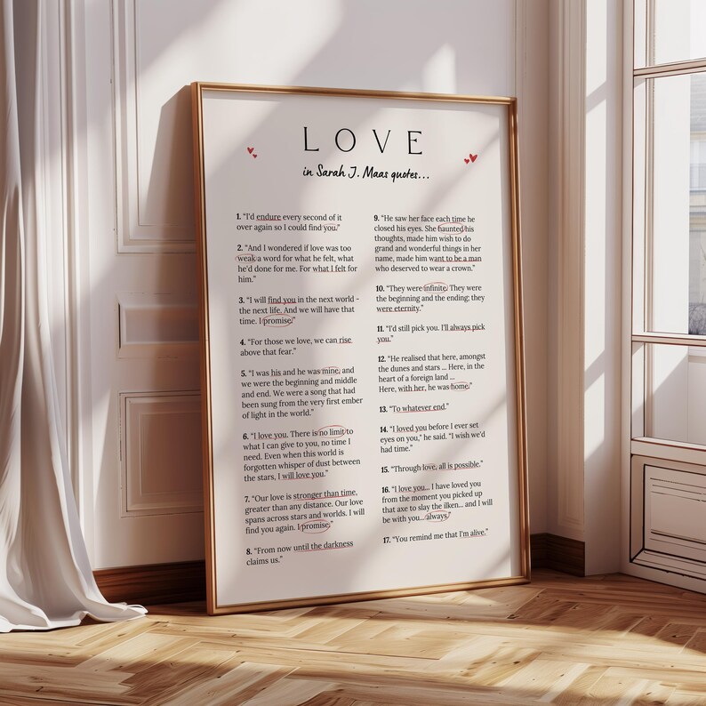 May include: A framed print with the word "LOVE" and quotes by Sarah J. Maas. The print has a gold frame and features red heart accents. The text is in black on a white background, with a list of quotes.
