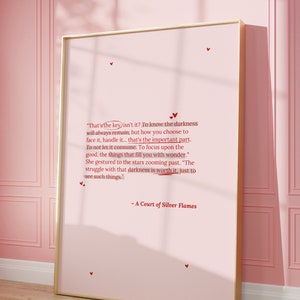 May include: A pink framed print with a quote from the book "A Court of Silver Flames" by Sarah J. Maas. The quote reads: "That's the key isn't it? To know the darkness will always remain, but how you choose to face it, handle it... that's the important part. To not let it consume. To focus upon the good, the things that fill you with wonder." She gestured to the stars zooming past. "The struggle with that darkness is worth it, just to see such things."