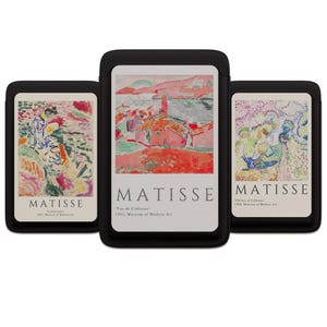 May include: Three black cases with art prints by Matisse. The prints feature colorful landscapes and figures. The text "MATISSE" is displayed prominently on each case, along with the title and museum information.