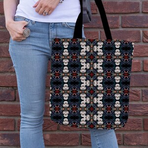 Könnte beinhalten: Eine Tragetasche mit schwarzem Hintergrund und einem sich wiederholenden Muster aus weißen, grauen und roten geometrischen Formen. Die Tasche hat schwarze Henkel.