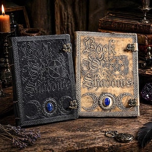 Puede incluir: Dos libros de estilo antiguo con el t&iacute;tulo "Book of Shadows" en relieve en las cubiertas. Uno es negro, el otro es marr&oacute;n claro. Ambos tienen dise&ntilde;os intrincados, un pentagrama y un cierre de piedra azul. Los libros est&aacute;n sobre una superficie de madera.