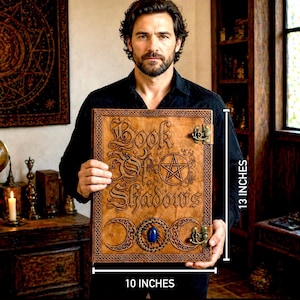 Puede incluir: Un libro encuadernado en cuero marr&oacute;n con el t&iacute;tulo "Book of Shadows" en relieve. El libro presenta un pentagrama, medias lunas y una piedra preciosa azul. Mide 25 cm de ancho y 33 cm de alto.