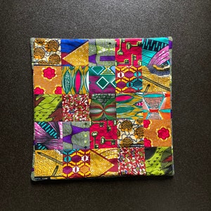 May include: A colorful patchwork fabric with a variety of geometric and floral patterns. The fabric is made up of squares and rectangles of different colors and designs, including green, red, yellow, blue, and purple.