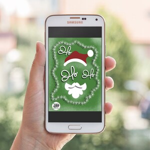 May include: A white Samsung smartphone with a green screen displaying a white and red Santa Claus illustration with the text "Ho Ho Ho" in white. The background is a green and white glitter design.