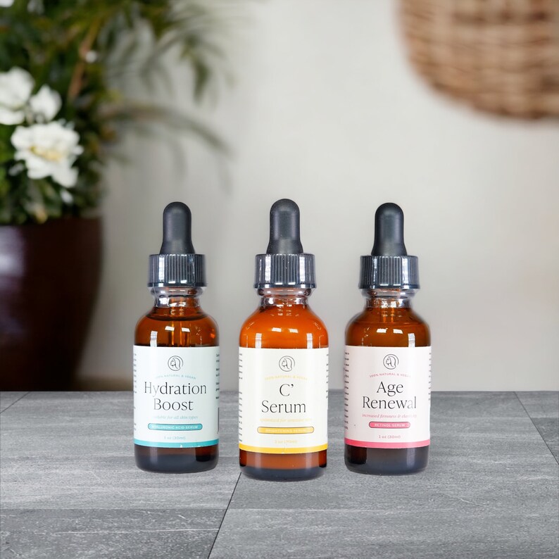 Puede incluir: Tres botellas de vidrio &aacute;mbar con goteros negros y etiquetas blancas. Las etiquetas tienen el texto "Hydration Boost", "C Serum" y "Age Renewal".
