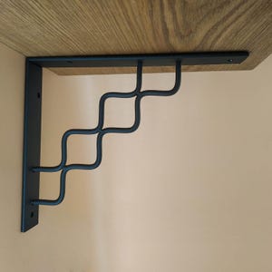 Forged shelf brackets with ornate metal plates. Industrial decor cornices, consoles for shelves. Accessories for shelves, brackets for racks