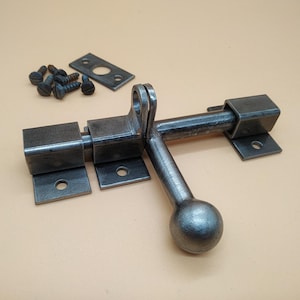 A door latch, handcrafted in a rustic style, ensures reliable and easy closure of doors.