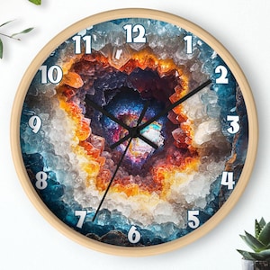 May include: A round clock featuring a colourful crystal geode design. The clock face has white numbers and black hands. The geode features shades of blue, orange, yellow, and purple.