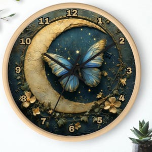 May include: A round clock with a blue butterfly on a crescent moon against a dark blue background with gold accents and white flowers. The clock face has Roman numerals and a gold-colored frame.