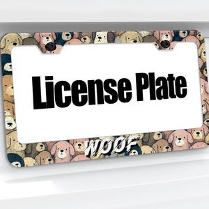 May include: A license plate frame with a repeating pattern of various dog breeds in shades of brown, tan, and pink. The frame has the word "WOOF" at the bottom and the words "License Plate" in bold black letters.