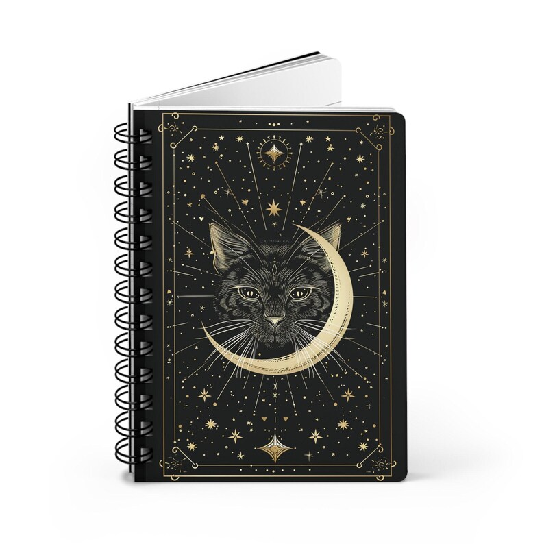 Standing spiral notebook angled slightly to show the black front cover with gold cat and moon design.