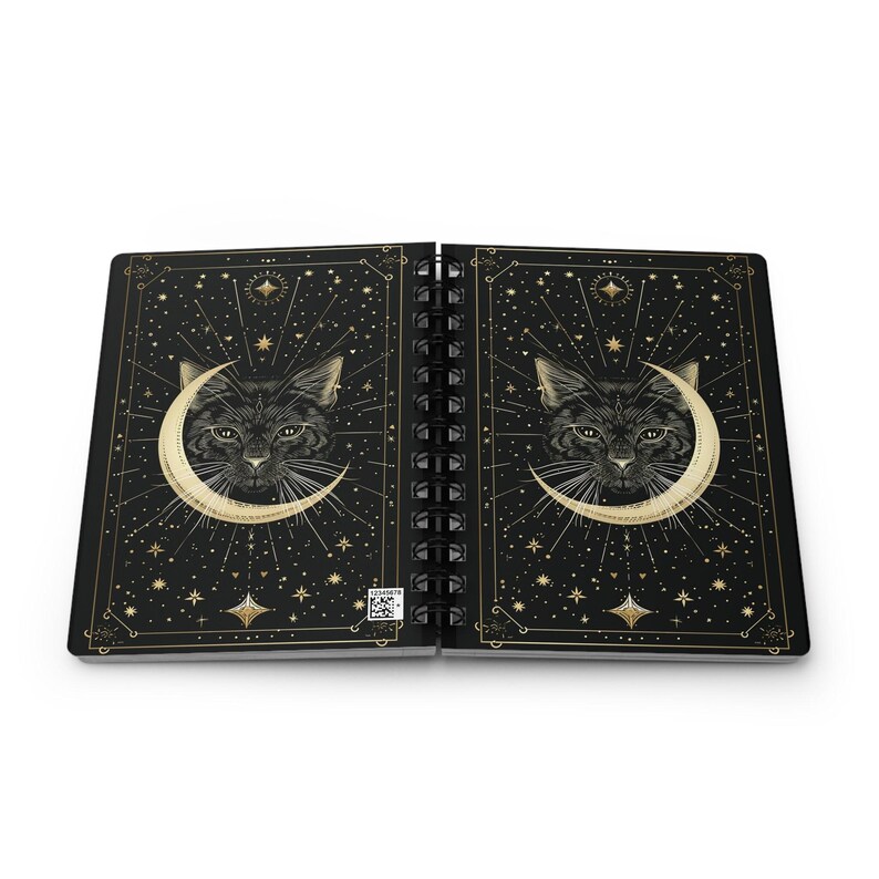 Fully open spiral notebook displaying the front and back covers flat side by side, showing the complete celestial cat design.