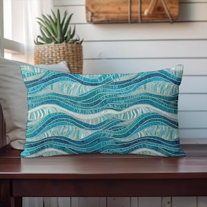 May include: A rectangular throw pillow featuring a repeating pattern of flowing, wavy lines in various shades of teal, turquoise, navy blue, and white. The design consists of horizontal, undulating bands that create a rhythmic, layered effect.