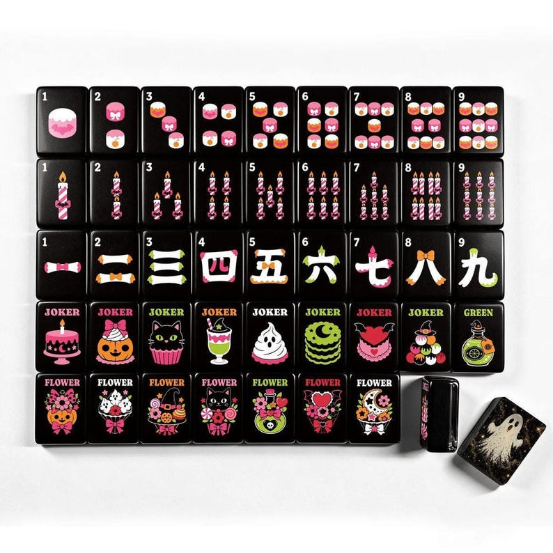 A full 160-piece set of black mahjong tiles with colorful pastel Halloween designs is neatly arranged on a white surface.