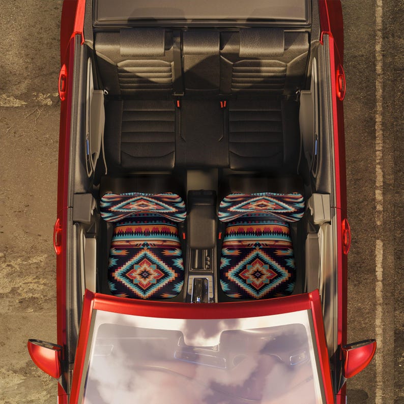 An overhead view of a red car's interior, showing two front seats fitted with colorful geometric patterned seat covers.