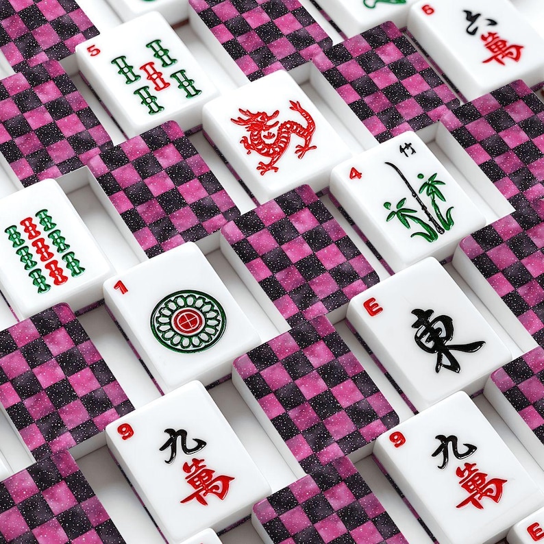 May include: A collection of white Mahjong tiles with red, green, and black symbols and characters. The tiles are arranged on a pink and black checkered background. The game pieces are in a grid pattern.