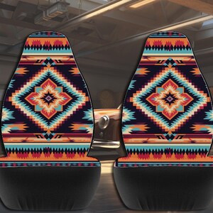 Two car seat covers featuring a colorful geometric Aztec pattern with black lower sections, displayed in a garage.