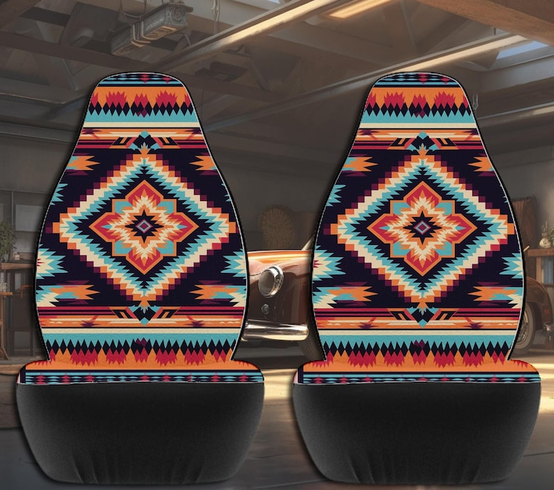 Two car seat covers featuring a colorful geometric Aztec pattern with black lower sections, displayed in a garage.