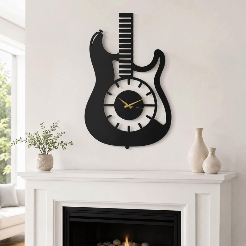 K&ouml;nnte beinhalten: Eine schwarze Wanduhr in Form einer E-Gitarren-Silhouette. Die Uhr verf&uuml;gt &uuml;ber ein zentrales, kreisf&ouml;rmiges Zifferblatt mit wei&szlig;en Stundenmarkierungen, einer soliden schwarzen Mitte und d&uuml;nnen goldfarbenen Zeigern f&uuml;r Stunden, Minuten und Sekunden. Der Gitarrenhals erstreckt sich nach oben mit horizontalen Bundlinien.