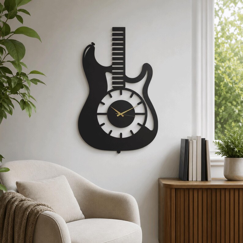 K&ouml;nnte beinhalten: Eine mattschwarze Wanduhr in Form einer E-Gitarren-Silhouette. Die Uhr verf&uuml;gt &uuml;ber ein zentrales, kreisf&ouml;rmiges Zifferblatt mit zw&ouml;lf strahlenf&ouml;rmigen Stundenmarkierungen und zwei d&uuml;nnen, goldfarbenen Zeigern. Der Gitarrenhals ragt vertikal empor.