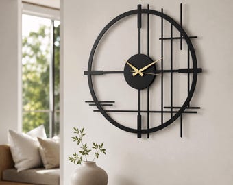 May include: A large circular wall clock featuring a black metal frame with geometric vertical and horizontal lines. The center consists of a solid black circular dial with thin gold-colored hour and minute hands, creating a stark contrast.