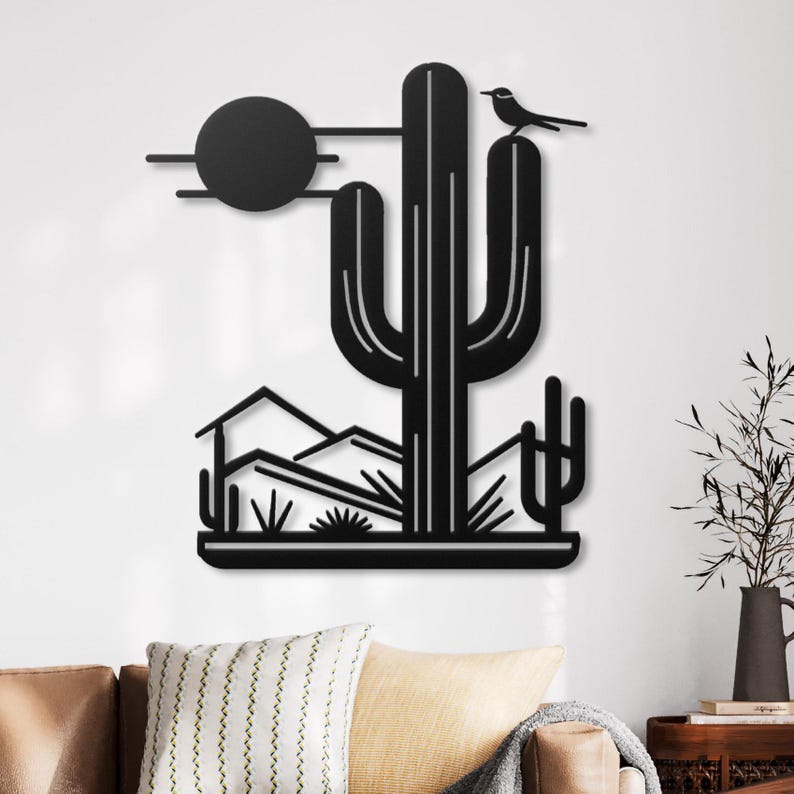 May include: Black metal wall art featuring a desert scene with a large cactus, a small bird perched on top, and a stylised sun in the background.