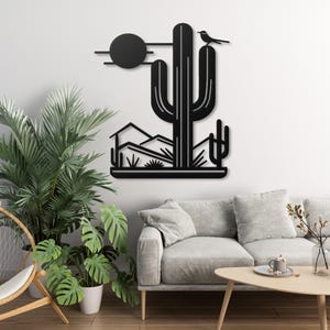 May include: Black metal wall art featuring a desert scene with a large cactus, a small bird perched on top, and a sun in the background.