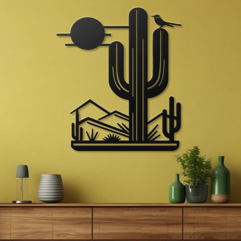 May include: Black metal wall art depicting a desert scene with a large cactus, a small bird perched on top, and a sun in the background.