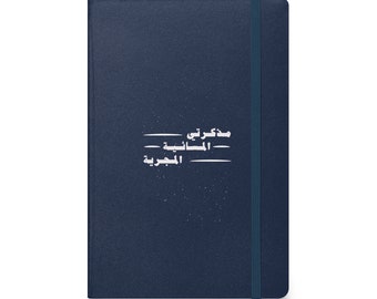 May include: A dark blue notebook with a white elastic closure. The cover has a white inscription in Arabic that reads "My Thoughts - The Universe".
