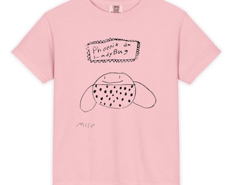 May include: A light pink t-shirt featuring a hand-drawn ladybug design. The ladybug has a dotted pattern and is accompanied by the text "Phoenix da LadyBug" in a rectangular frame. The artist's signature, "milo," is at the bottom.
