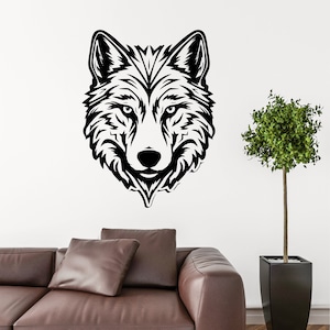 May include: Black and white silhouette of a wolf's head, with a detailed design of fur and facial features. The wolf's head is centered on a white wall, with a brown leather couch and a potted plant in the background.