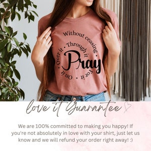 May include: A pink t-shirt with a black circle graphic that says "Without ceasing, Through it, Pray for it, On it, Over it". The text is in a cursive font. The shirt is being modeled by a person. The text "love it Guarantee" is at the bottom of the image.