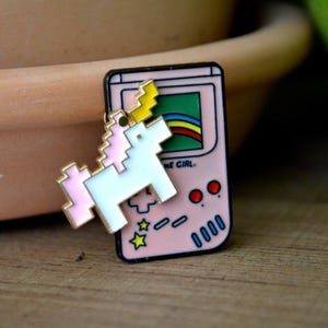level up with a Rainbow Gameboy pin and a spinning unicorn – Cute Gamer Girl Enamel Pin