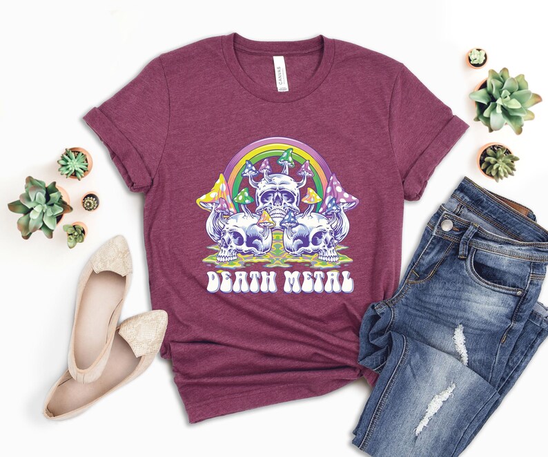 May include: A maroon t-shirt with a graphic of a skull with mushrooms and a rainbow. The text "Death Metal" is printed below the graphic.