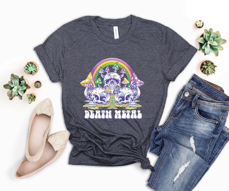 May include: A dark heather grey t-shirt with a graphic of a rainbow, mushrooms, and skulls. The text "Death Metal" is printed in a retro font below the graphic.