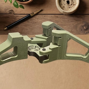 May include: A green 3D printed object with a unique design. The object is made of two pieces that fit together. The object is on a wooden surface.