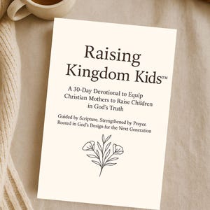 Puede incluir: Un libro color crema titulado "Raising Kingdom Kids" con texto que describe un devocional de 30 días para madres cristianas. Una taza de té y un libro abierto están en el fondo. El libro tiene una ilustración floral.