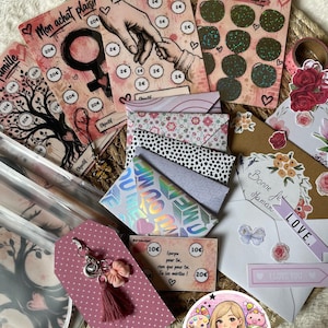 Peut inclure: Un assortiment de cartes décoratives, d'enveloppes et d'étiquettes avec divers motifs et textes. Les cartes présentent des illustrations, du texte et des motifs de cœur. La palette de couleurs comprend le rose, le blanc et le marron.