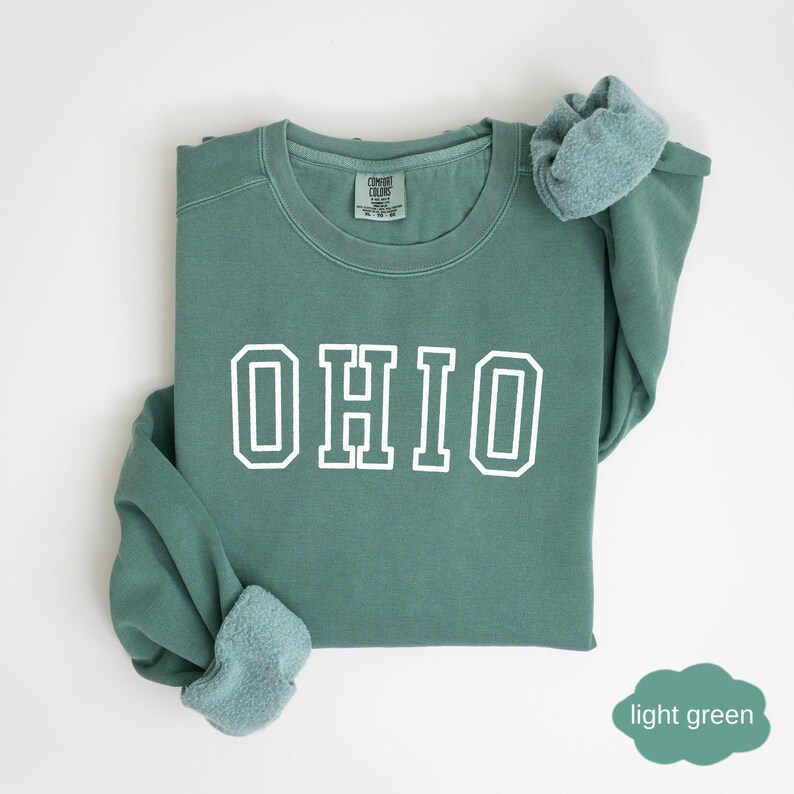 May include: A light green sweatshirt with the word "OHIO" printed in white on the front.