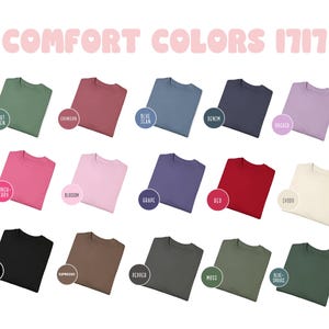 May include: A collection of 18 t-shirts in various colors, including light green, crimson, blue jean, denim, orchid, couch-berry, blossom, grape, red, ivory, black, espresso, pepper, moss, blue spruce, and more. The t-shirts are laid out in three rows of six, with each t-shirt folded in half and placed on a white background. The text "COMFORT COLORS 1717" is displayed at the top of the image.