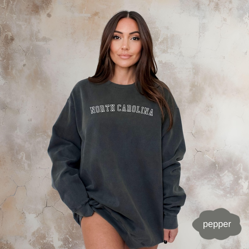 May include: A dark gray sweatshirt with the text "NORTH CAROLINA" in white outlined letters.