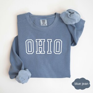 May include: A blue jean sweatshirt with white lettering that says "OHIO".