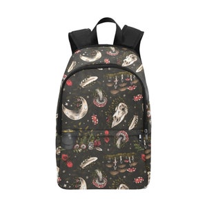 May include: Black backpack featuring a repeating pattern of moons, mushrooms, feathers, and skulls. The backpack has black shoulder straps and a top handle. The design includes red, white, and green accents on a dark background.